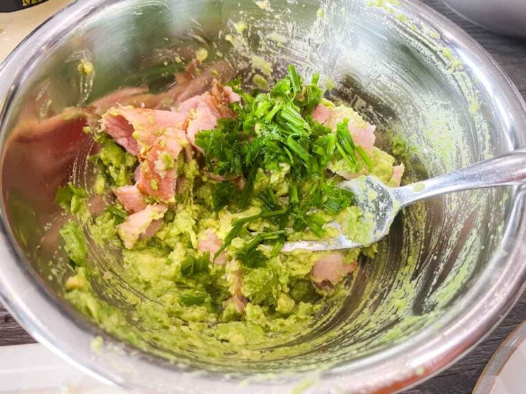 mixing avodado with bacon and herbs